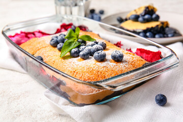 Baking dish with blueberry cobbler on light background, closeup