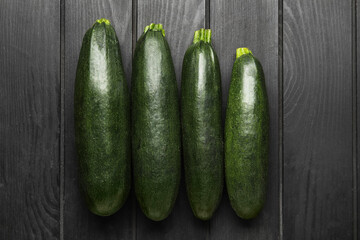 Fresh zucchini squashes on dark wooden background