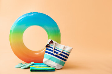 Inflatable ring and beach accessories on color background