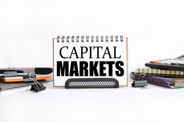 CAPITAL MARKETS. text on notepad. on a white background near the stationery