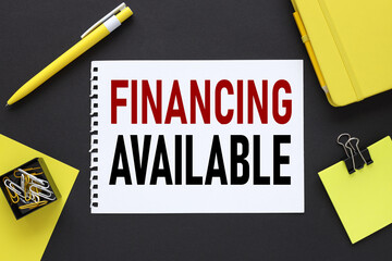 Financing Available. text on a black background, on white paper, next to bright stickers and a...