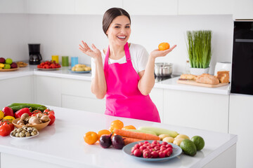 Photo of impressed brunette hair young lady hold tomato from home wear white t-shirt apron at kitchen