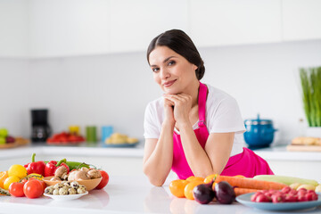 Photo portrait woman in apron standing near fersh vegetables in kitchen at home