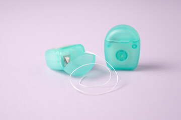 Pocket floss. Mint dental floss cases isolated. Open dental floss containers on purple background....