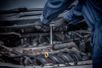 Car mechanic opens the hood used screwdrivers to check and fix system for customers at the garage ,car service concept.
