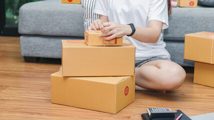 Woman packing parcel box. Successful entrepreneur business woman with online sales and Parcel shipping in her home office.