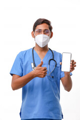 Young indian doctor showing smartphone screen over white backgro