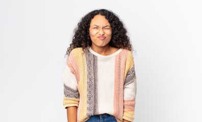 pretty hispanic woman looking goofy and funny with a silly cross-eyed expression, joking and...