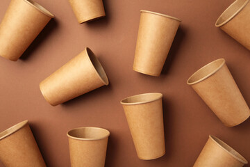 Disposable paper cups on brown background. Coffee concept.