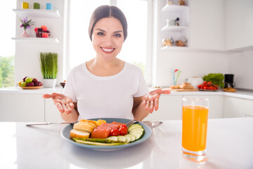 Photo of cheerful young attractive charming woman smile show hands meal dinner indoors inside home kitchen