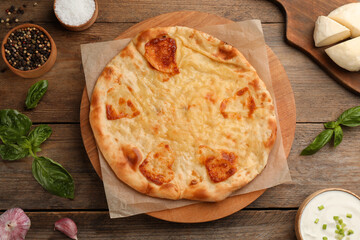 Delicious khachapuri with cheese on wooden table, flat lay