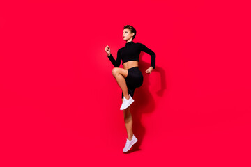 Profile photo of runner serious lady jogging training wear black cropped top isolated red color background