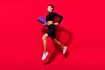 Fototapeta na wymiar Profile photo of runner cheerful lady jogging carry mat carpet wear black cropped top isolated red color background