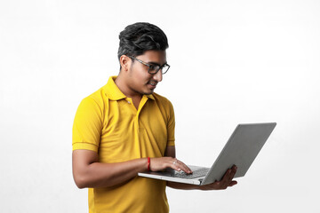 young indian man using laptop.