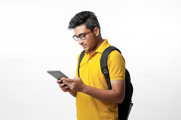 Young indian college student using tablet over white background.