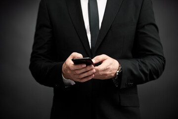 Close up of man in suit using smart phone