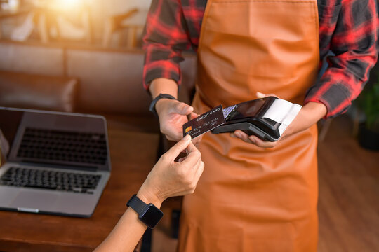 Woman making a contactless payment on a credit card reader