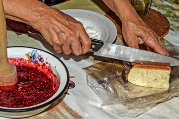 The hostess cuts a piece of homemade cake for breakfast