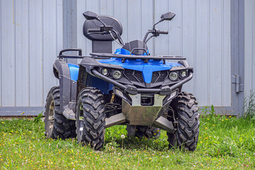 The ATV is parked near the house on a summer day © vladimir subbotin
