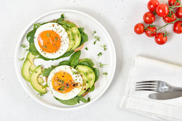 Bread with fried eggs, avocado and greens. Healthy breakfast
