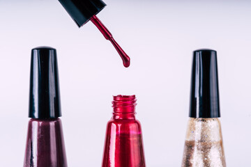 Close up of brilliant nail polish on isolated white background. Bright red lacquer for manicure