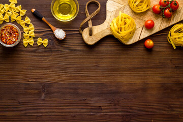 Flat lay of pasta ingredients with tomatoes olive oil spices