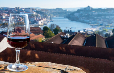 Tasting of different fortified dessert ruby, tawny port wines in glasses with view on Douro river, porto lodges of Vila Nova de Gaia and city of Porto, Portugal - obrazy, fototapety, plakaty