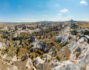 Fototapeta na wymiar Aerial View of Goreme valley in Turkey. Panorama of Cappadocia - wide angel landscape mountain peaks of ancient cave town Uchisar.