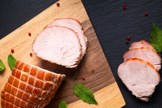 Food concept organic turkey or chicken cured ham German Kassler or Kasseler on wooden board with copy space