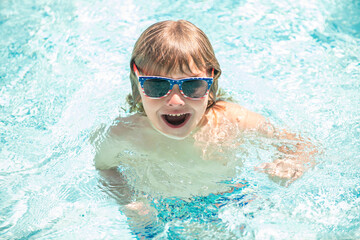 Fototapeta na wymiar happy child boy in glasses swimming in pool, summer vacation
