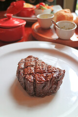 Closeup Delectable Grilled Filet Mignon Steak with Blurry Side Dish in the Backdrop