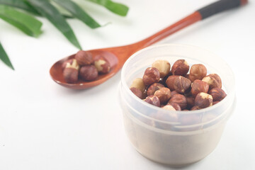 hazelnuts in a container on white background,