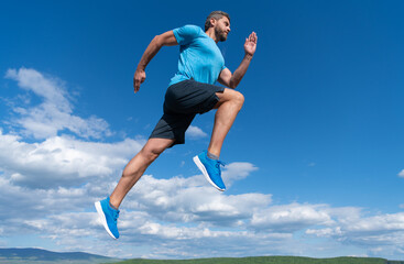Fototapeta na wymiar muscular man running in sportswear outdoor on sky background, challenge