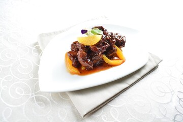 bbq wok fried pork ribs with sweet and sour orange sauce in white background asian halal menu