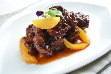 bbq wok fried pork ribs with sweet and sour orange sauce in white background asian halal menu