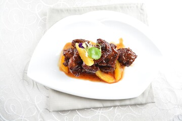 Fototapeta premium bbq wok fried pork ribs with sweet and sour orange sauce in white background asian halal menu