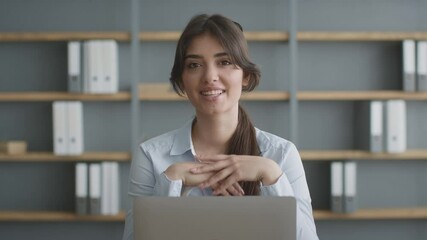 Online coaching. Young woman expert recording tutorial, sitting at office with laptop computer, talking to camera
