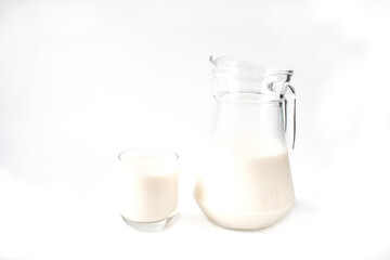 Pitcher and glass of milk isolated with white background.