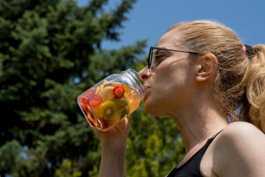 young woman enjoy detox drinks after doing pilates or yoga in their garden. - Powered by Adobe