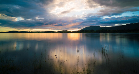 Sunset on the lake with the reflection of the sunset sky in the water