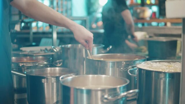 Soup is being stirred in the cooking pot