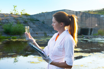 a female ecologist takes water samples for contamination, the concept of ecology.