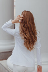 Fototapeta premium Beauty girl with brown curly hair. Healthy and long brown wavy hair. Beautiful young woman. Rear view