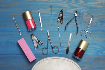 Flat lay composition with set of manicure tools on light blue wooden background