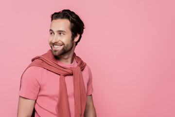 Cheerful man in t-shirt looking away isolated on pink