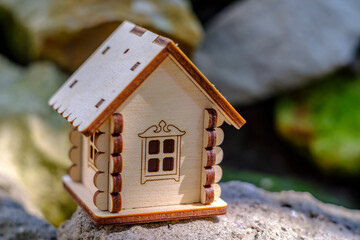 toy house on stone with greenery background