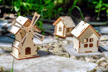 toy houses on a stone slab with greenery background