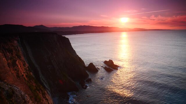 Sunset over rocky cliffs at Asturias coast in north Spain. View from Faro de Cabo Busto. Tourist attraction, place to visit.