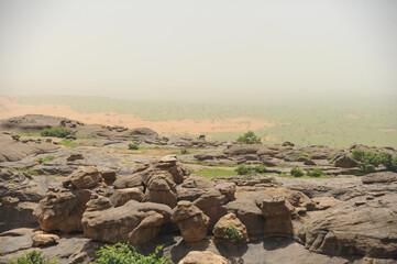Brown rocky hill and green ground on the horizon