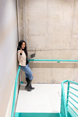 Brunette woman is working with her laptop from the stairs